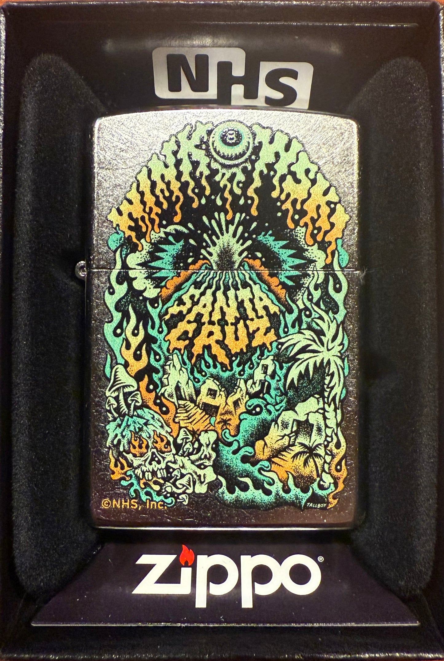 A Zippo lighter featuring a color(imaged) Santa Cruz Winkowski graphic on a chrome background, displayed in a black gift box with the 'NHS' logo at the top.