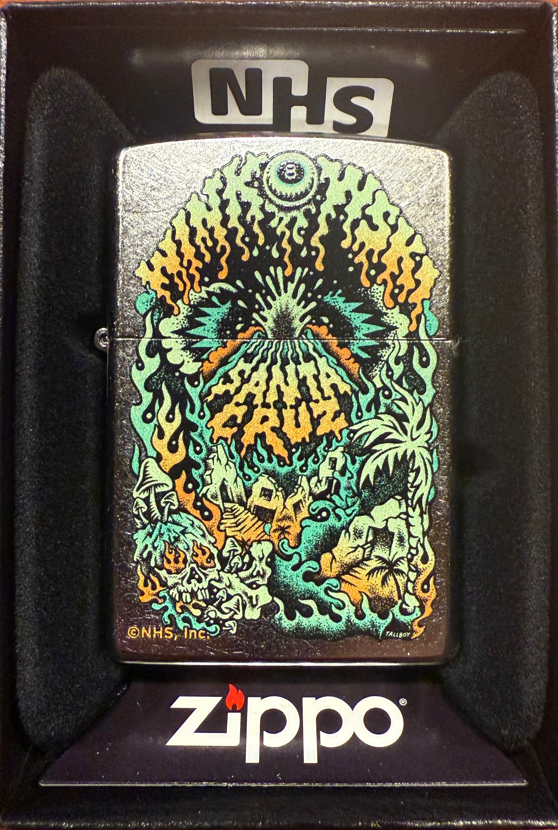 A Zippo lighter featuring a color(imaged) Santa Cruz Winkowski graphic on a chrome background, displayed in a black gift box with the 'NHS' logo at the top.