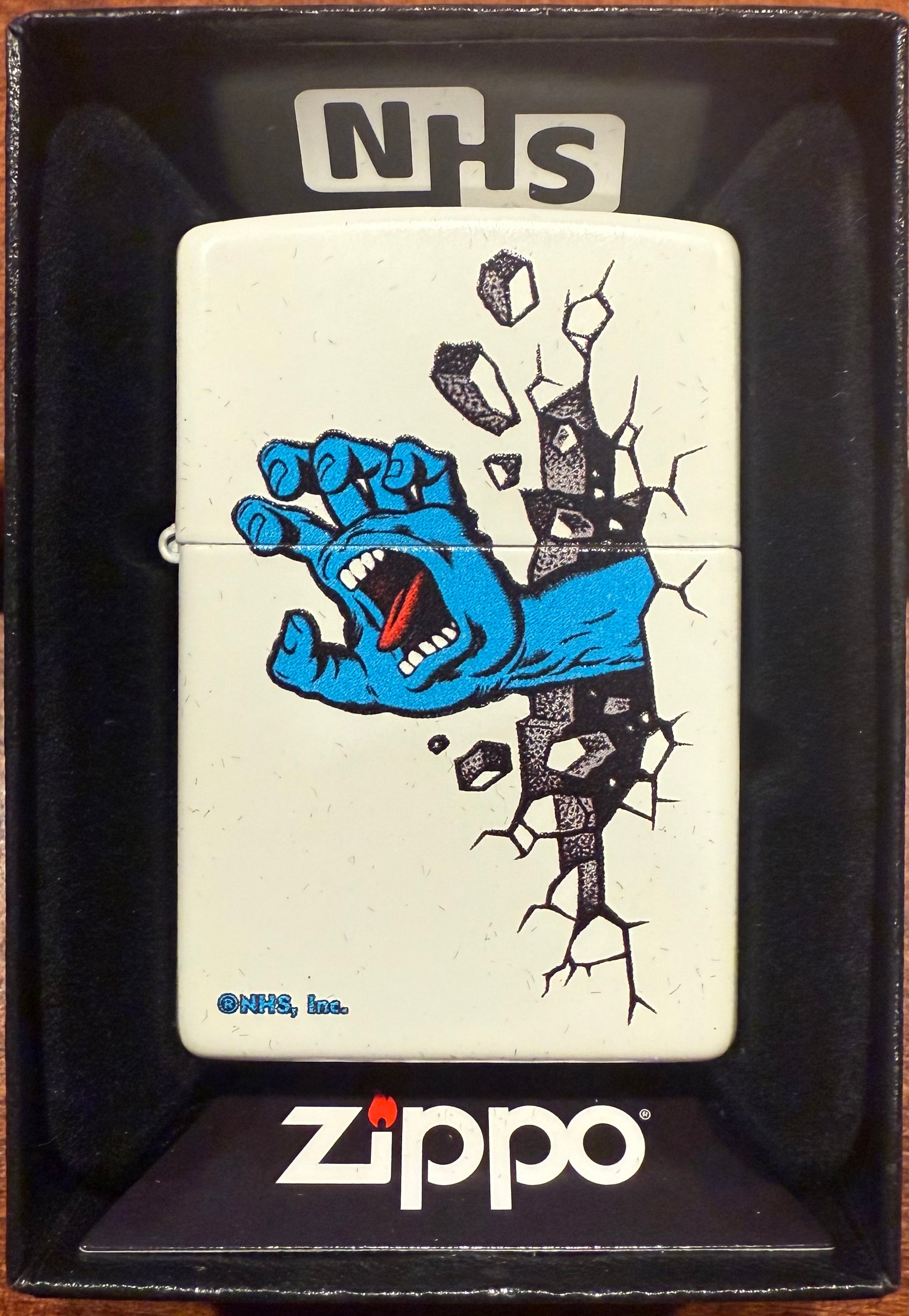 A white matte Zippo lighter with a color imaged Santa Cruz Screaming Hand graphic, packaged in a black gift box with 'Zippo' branding.